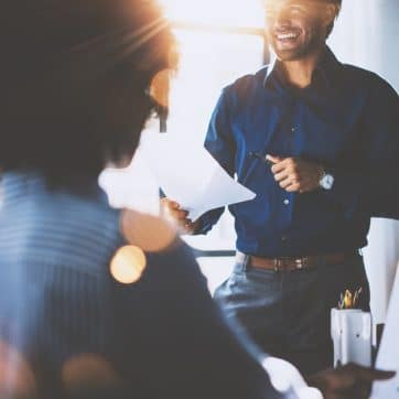 Hispanic,Businessman,Holding,Papers,Hands,And,Smiling.young,Team,Of,Coworkers